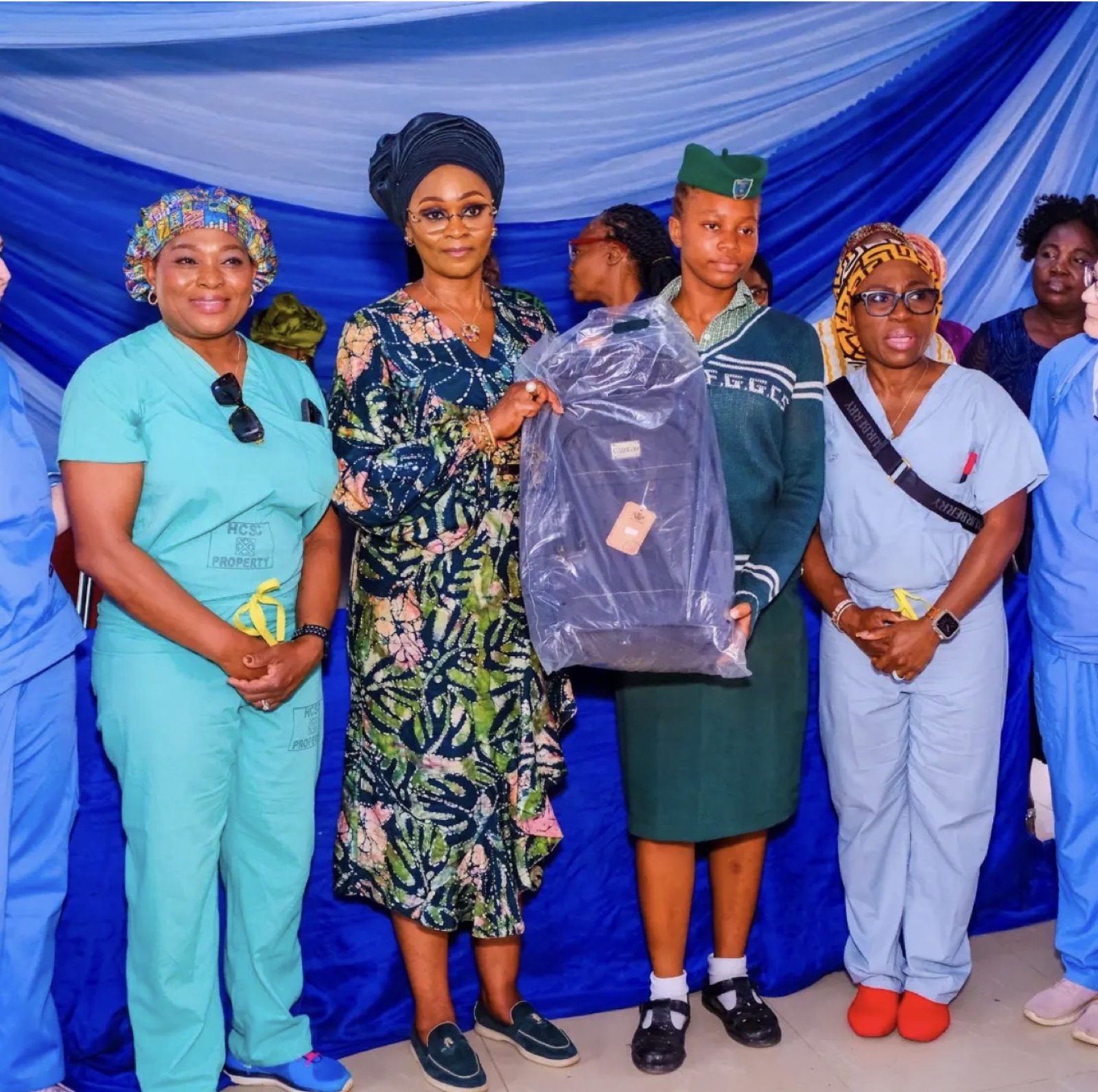 A student receiving a donated school bag at the Sagamu girls' outreach, 2026
